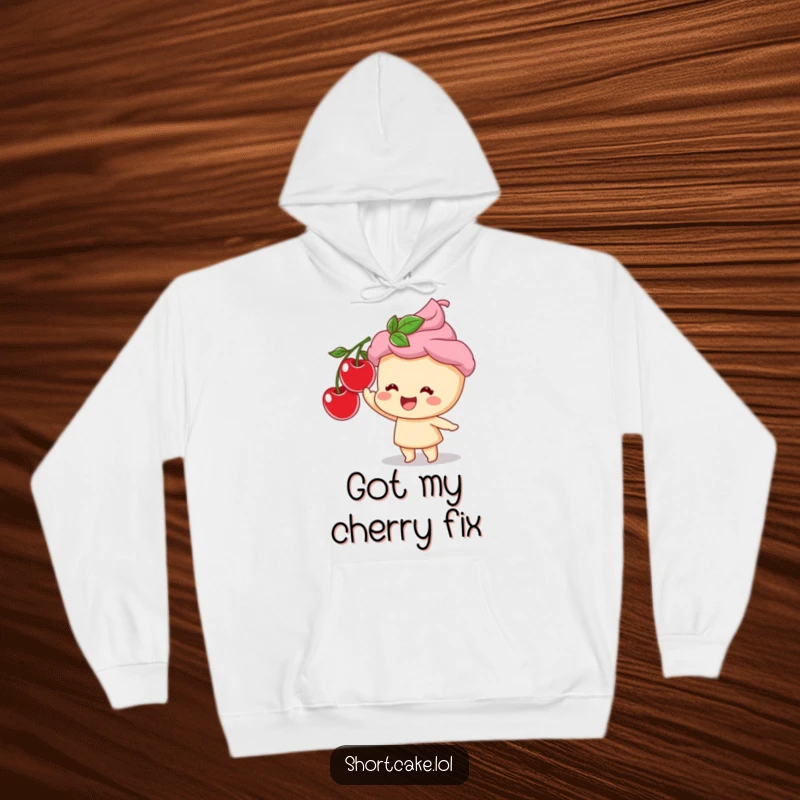 Funny hoodie showcasing a contented shortcake character eagerly reaching for a tempting cherry, radiating pure dessert joy.